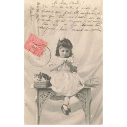 CHATS -MK39825 PETITE FILLE ASSISE SUR UNE COMMODE AVEC SON CHAT DANS UN PANIER
